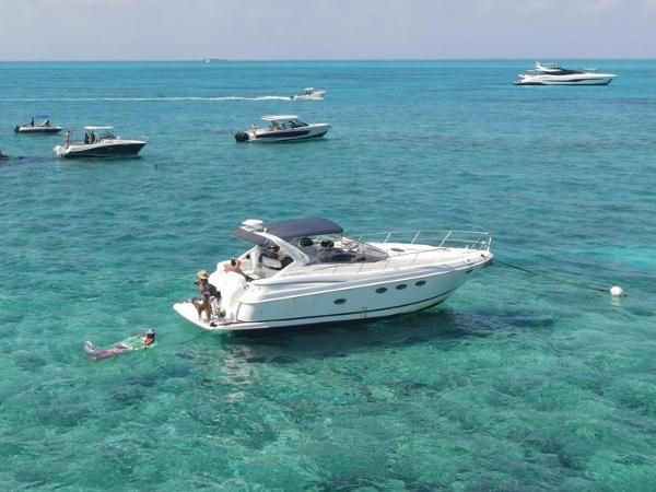Regal Commodore 3860 2003 Regal Commodore 3860 yacht anchored in clear turquoise waters, surrounded by smaller boats.