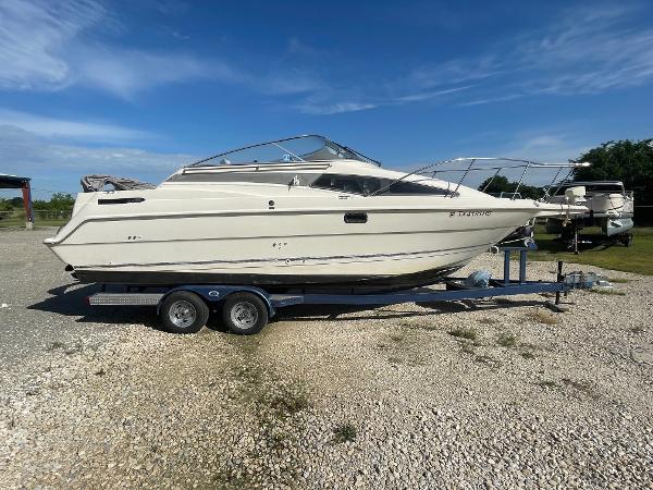 Bayliner 2655 Ciera 1994 Bayliner 2655 Ciera boat on a trailer in a gravel lot.