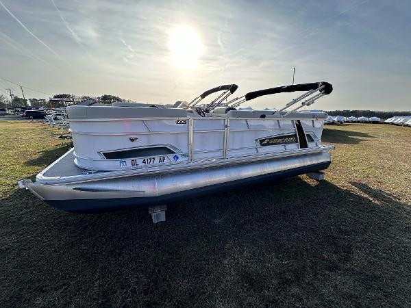 Starcraft EX 20 C 2023 Starcraft EX 20 C pontoon boat on grass under a bright sun.