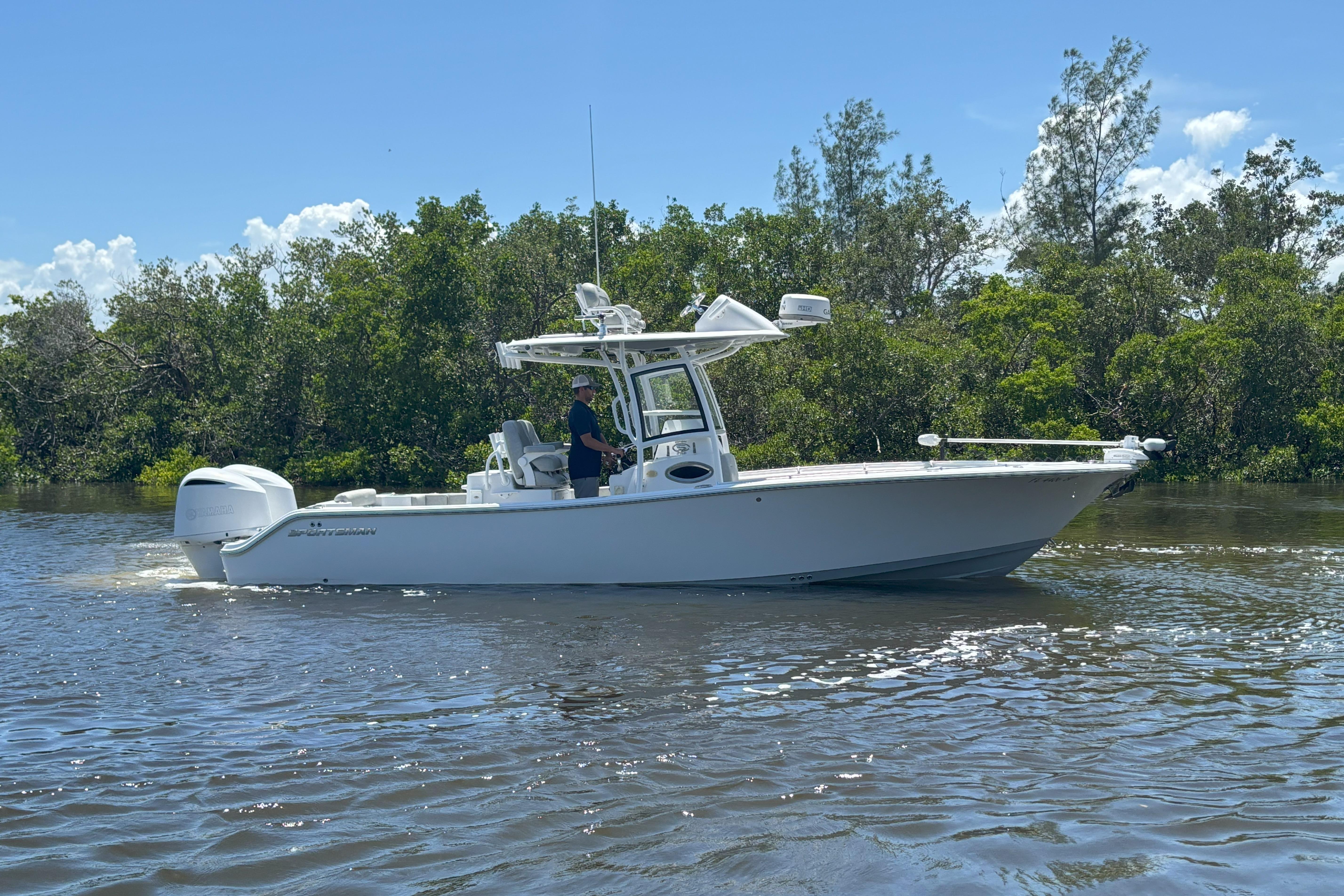Sportsman Open 282 Center Console 2020 Sportsman Open 282 Center Console boat cruising on a sunny day near lush greenery.
