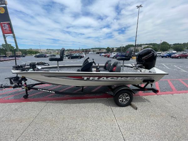 Tracker Pro Team 175 2025 Tracker Pro Team 175 boat on trailer in parking lot, under cloudy sky.