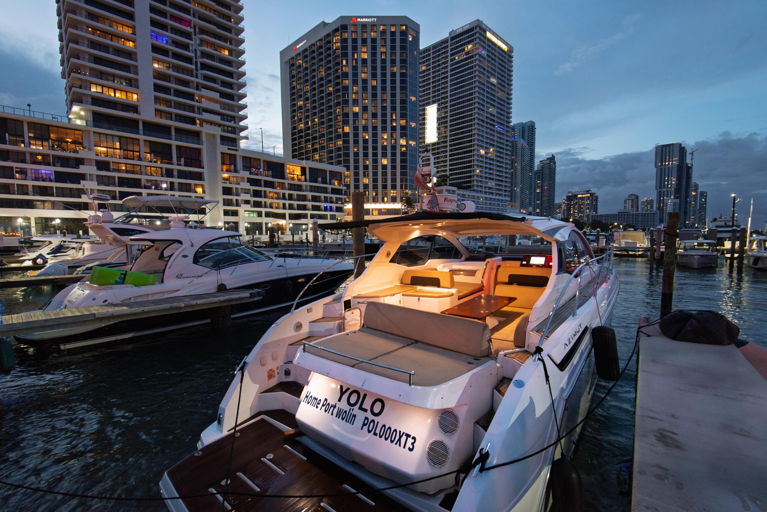 Azimut Atlantis 43 Azimut Atlantis 43 yacht docked at marina, city skyline in background, evening lights.