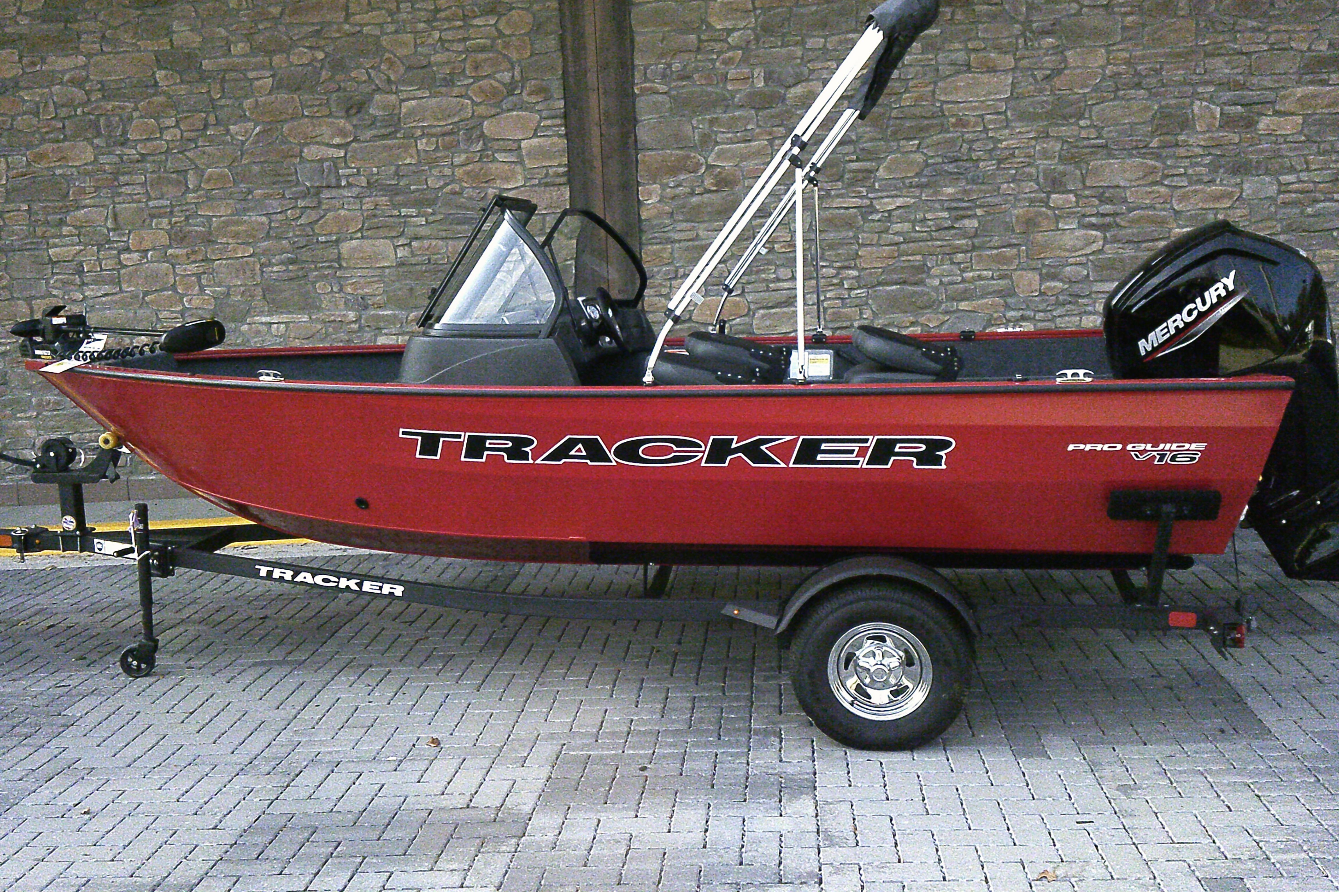 Tracker Pro Guide V-16 WT 2026 Tracker Pro Guide V-16 WT boat on trailer, red exterior, parked on brick pavement.