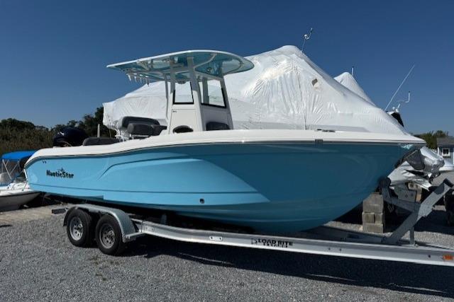 NauticStar 242L Offshore 2023 NauticStar 242L Offshore boat on trailer, light blue hull, parked outdoors.