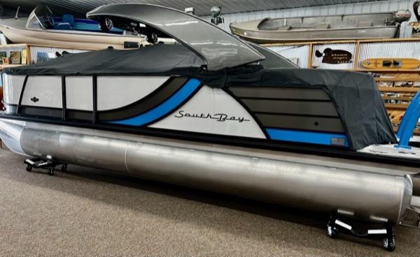 South Bay 523RS ARCH3.0 2023 South Bay 523RS ARCH3.0 pontoon boat in showroom, partially covered.