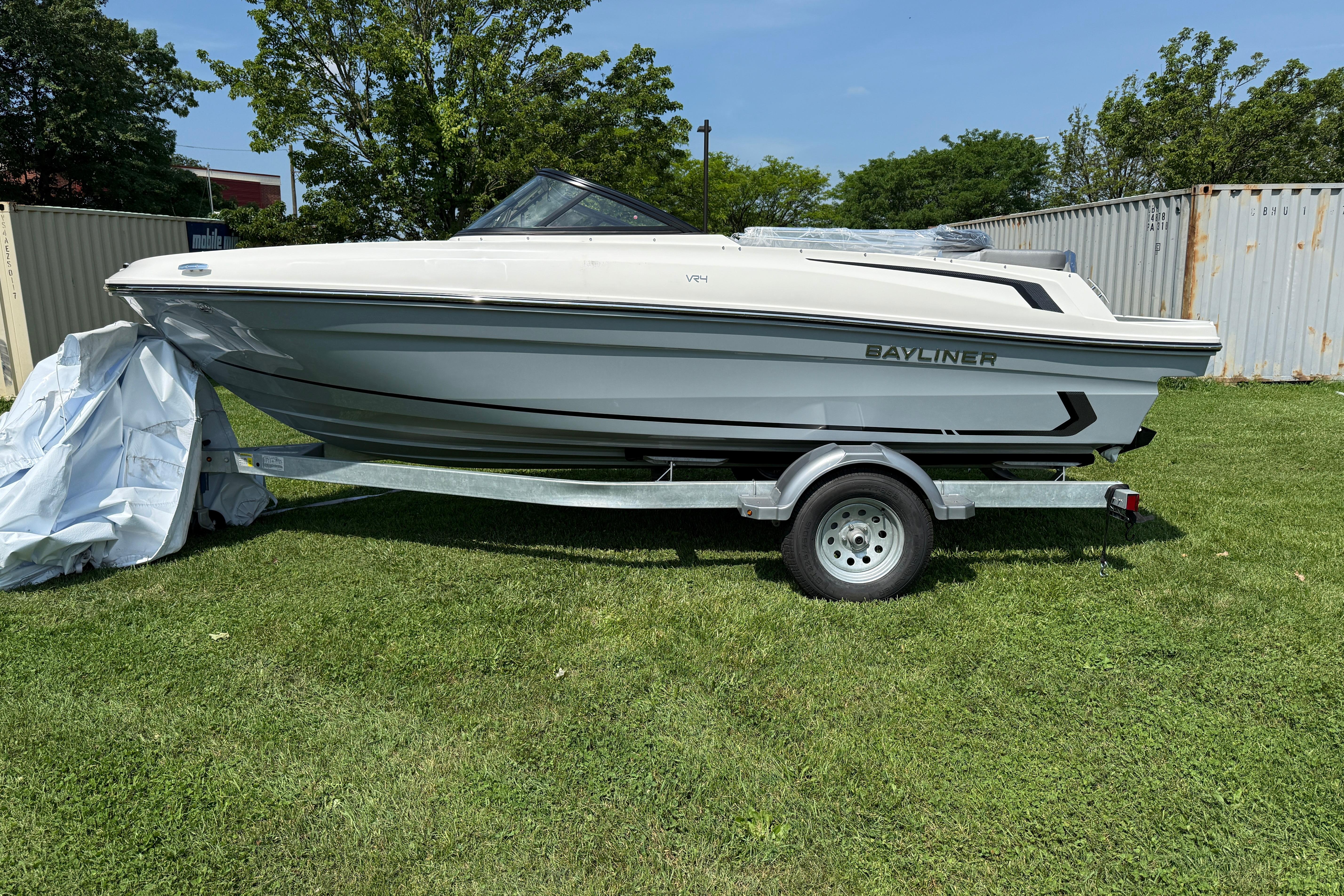 Bayliner VR4 Bowrider I/O 2025 Bayliner VR4 Bowrider I/O on trailer, parked on grass, under clear sky.