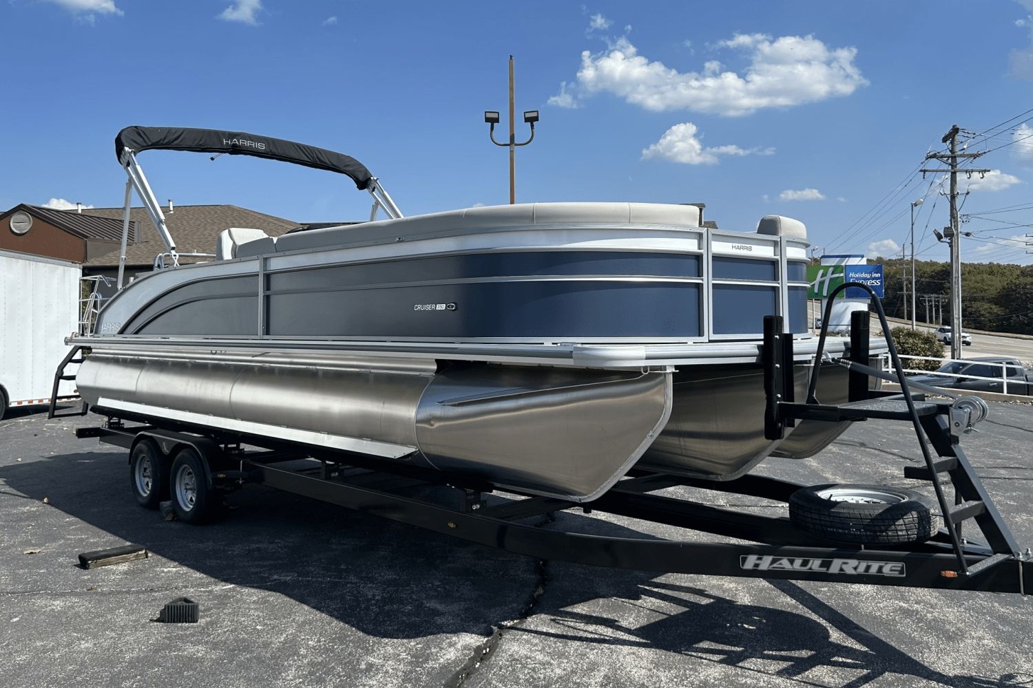 Harris 250 Cruiser 2025 Harris 250 Cruiser pontoon boat on HaulRite trailer under clear blue sky.