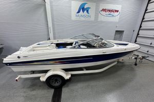 Bayliner 205 2005 Bayliner 205 BR boat in showroom, white and blue design, on trailer.
