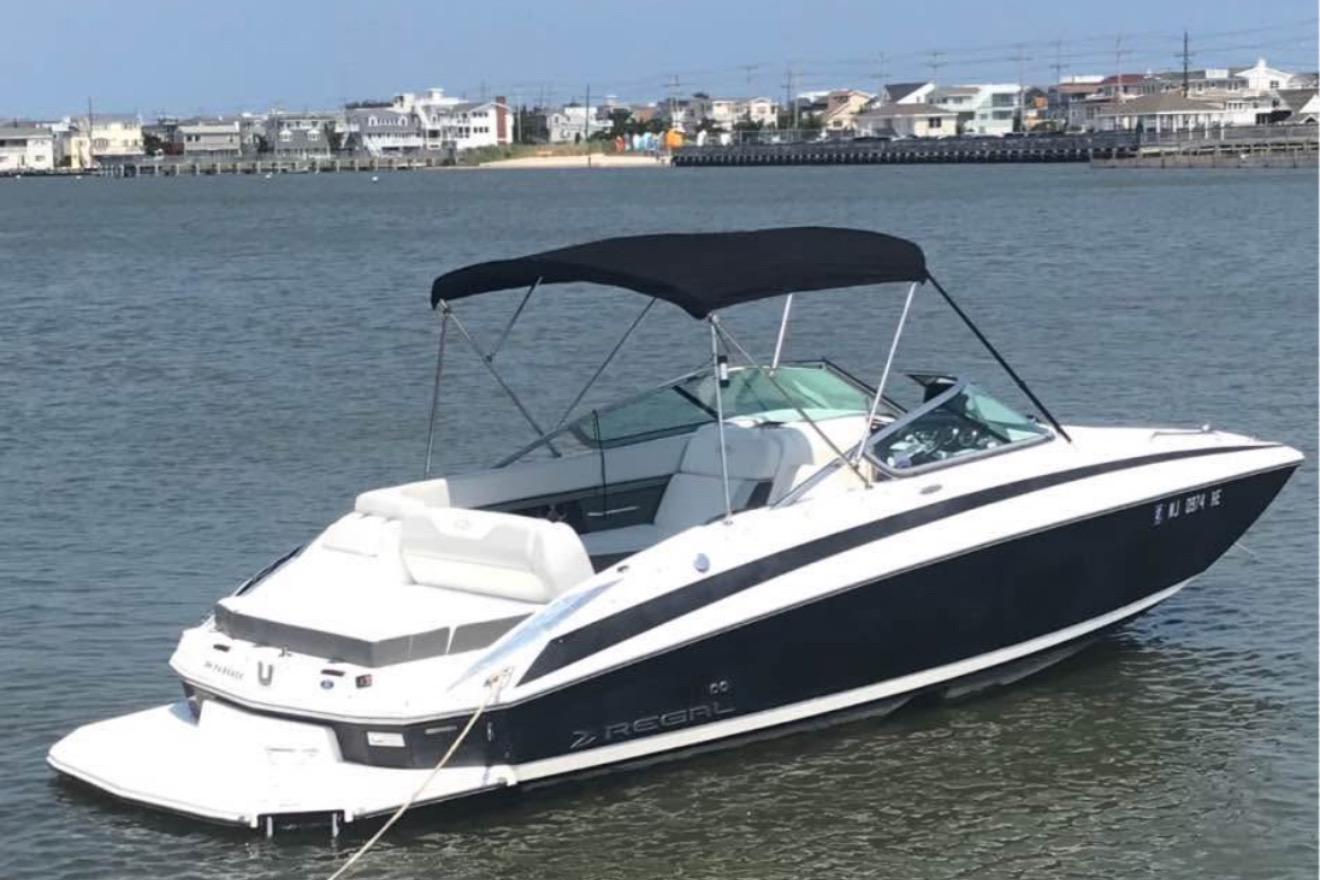Regal 24 FasDeck 2012 Regal 24 FasDeck boat with canopy on calm water near shoreline.