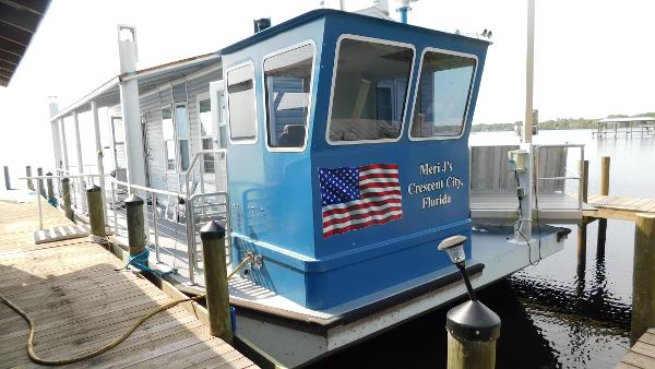 Custom 50 Houseboat Custom 50 Houseboat 2022 docked, featuring American flag and "Meri J's Crescent City, Florida" text.