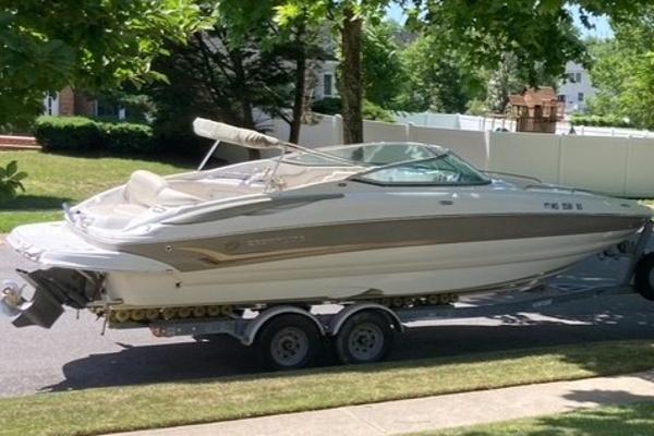 Crownline 262 EX 2006 Crownline 262 EX boat on trailer, parked on a sunny residential street.