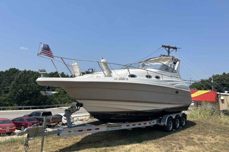 Regal Commodore 2860 2003 Regal Commodore 2860 boat on trailer, parked outdoors with American flag.