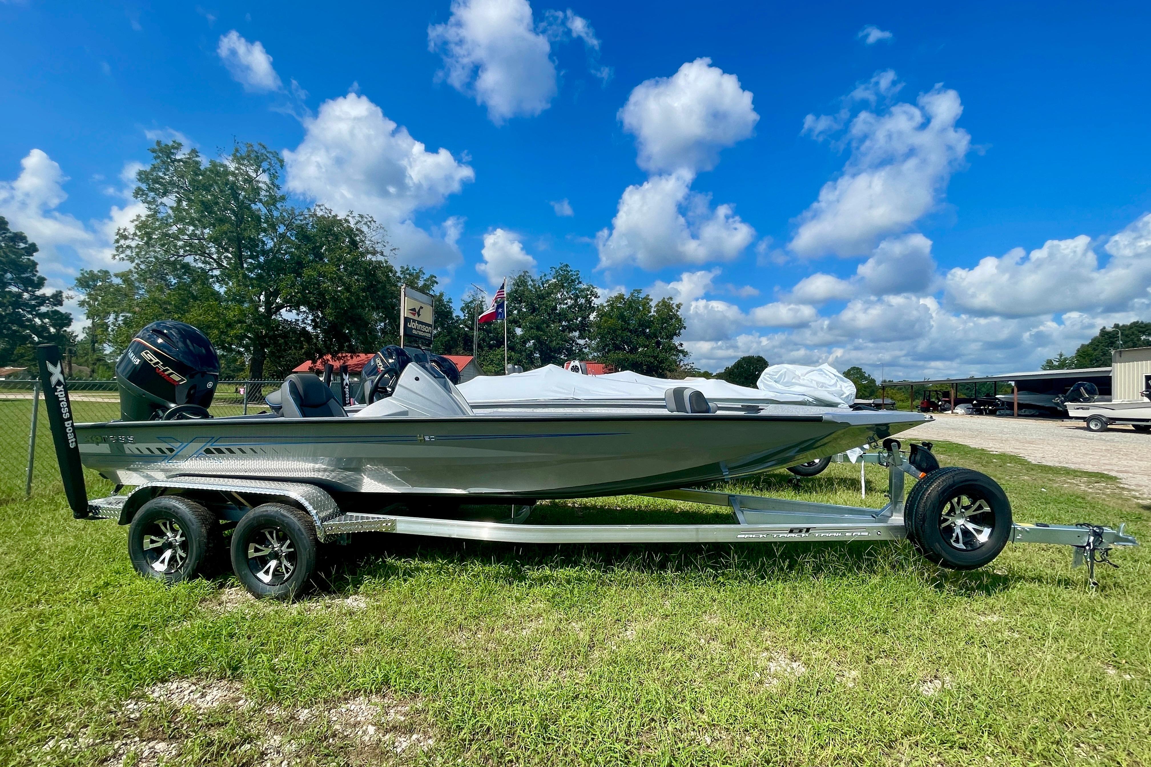 Xpress H20 Bass 2026 Xpress H20 Bass boat on trailer, parked on grass under a blue sky.