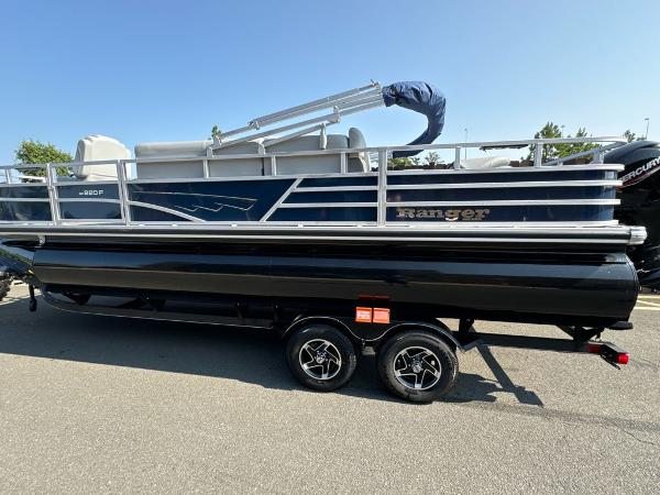 Ranger Reata 220F 2024 Ranger Reata 220F pontoon boat on trailer, side view, sunny day.
