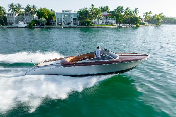 Riva Aquariva Super 2020 Riva Aquariva Super luxury speedboat cruising on a scenic waterfront.