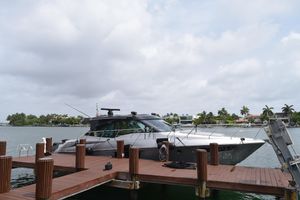 Cruisers Yachts 45 Cantius 2018 Cruisers Yachts 45 Cantius docked by waterfront homes under cloudy sky.