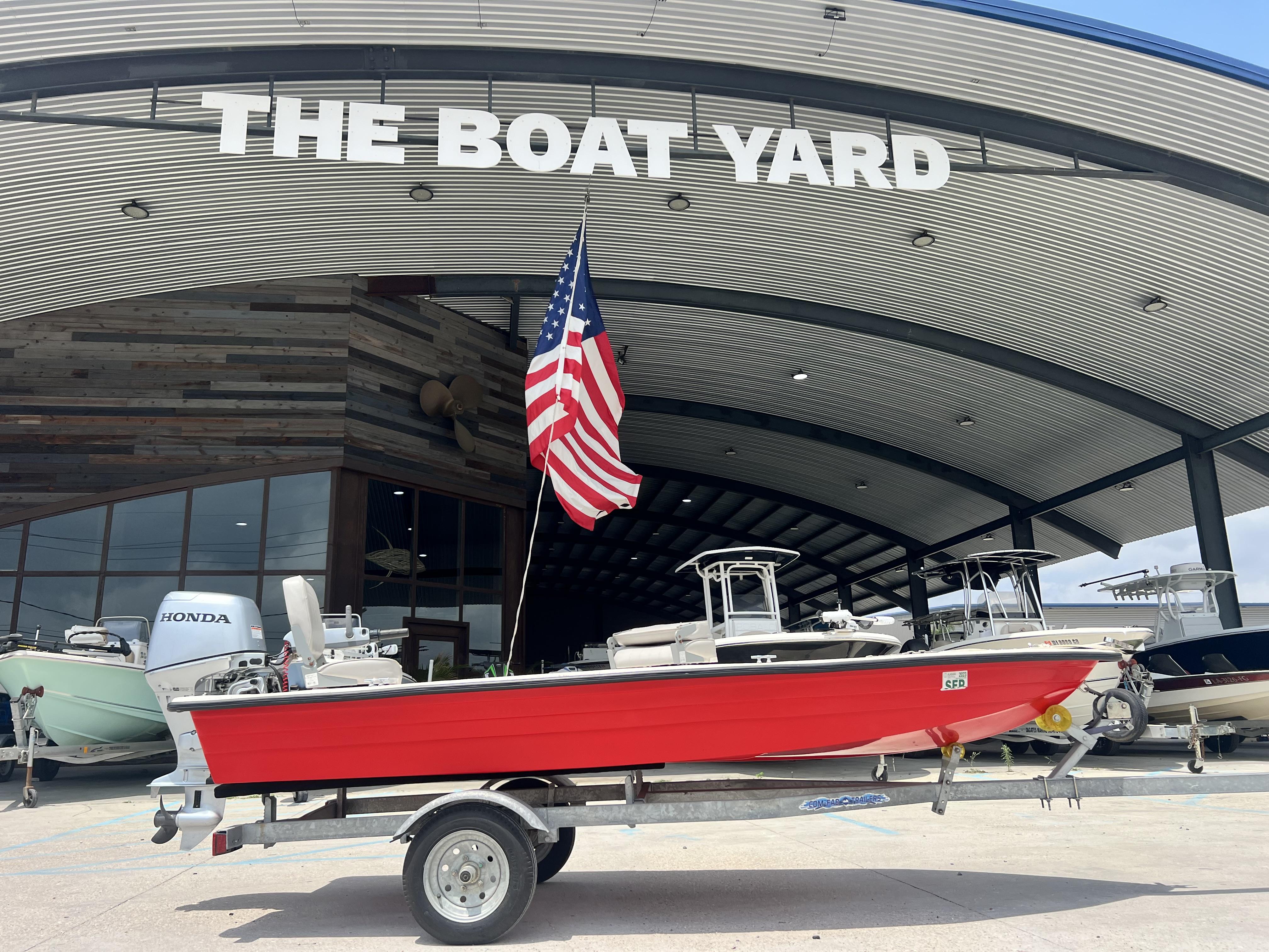 Custom 14 Red Custom 14 boat (2023) on trailer at The Boat Yard with American flag.