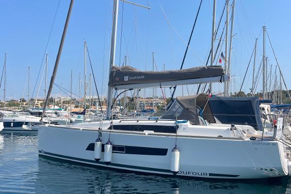 Dufour 32 2023 Dufour 32 sailboat docked in a marina, surrounded by other boats.