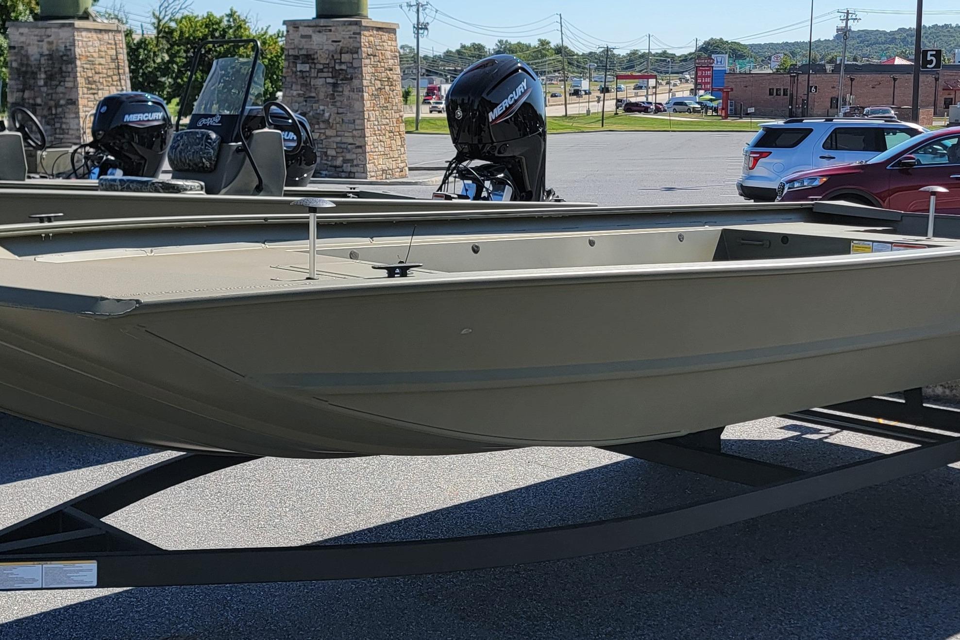 Tracker GRIZZLY 1860 Utility 2026 Tracker GRIZZLY 1860 Utility boat with Mercury outboard motors in a parking lot.