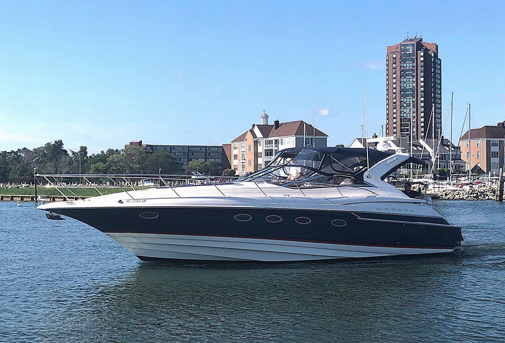 Regal Commodore 4460 2006 Regal Commodore 4460 yacht cruising near urban waterfront buildings.