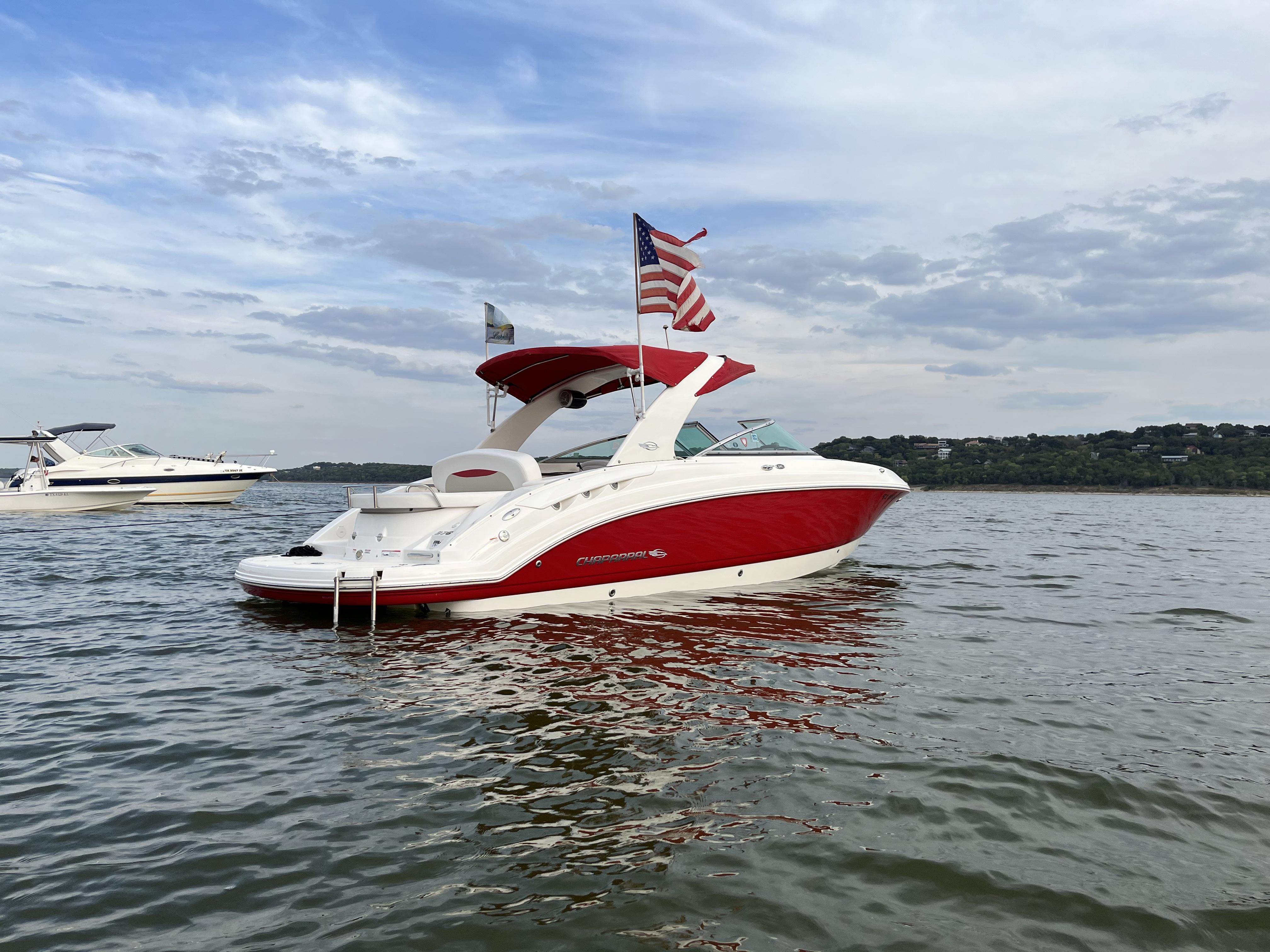 Custom 276Ssx Red and white 2008 Custom 276Ssx boat on a lake with American flag.