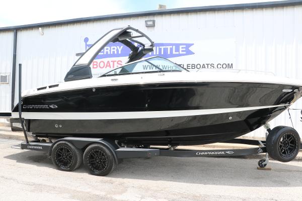 Chaparral 260 Surf 2024 Chaparral 260 Surf boat on trailer, black and white design, parked outside.