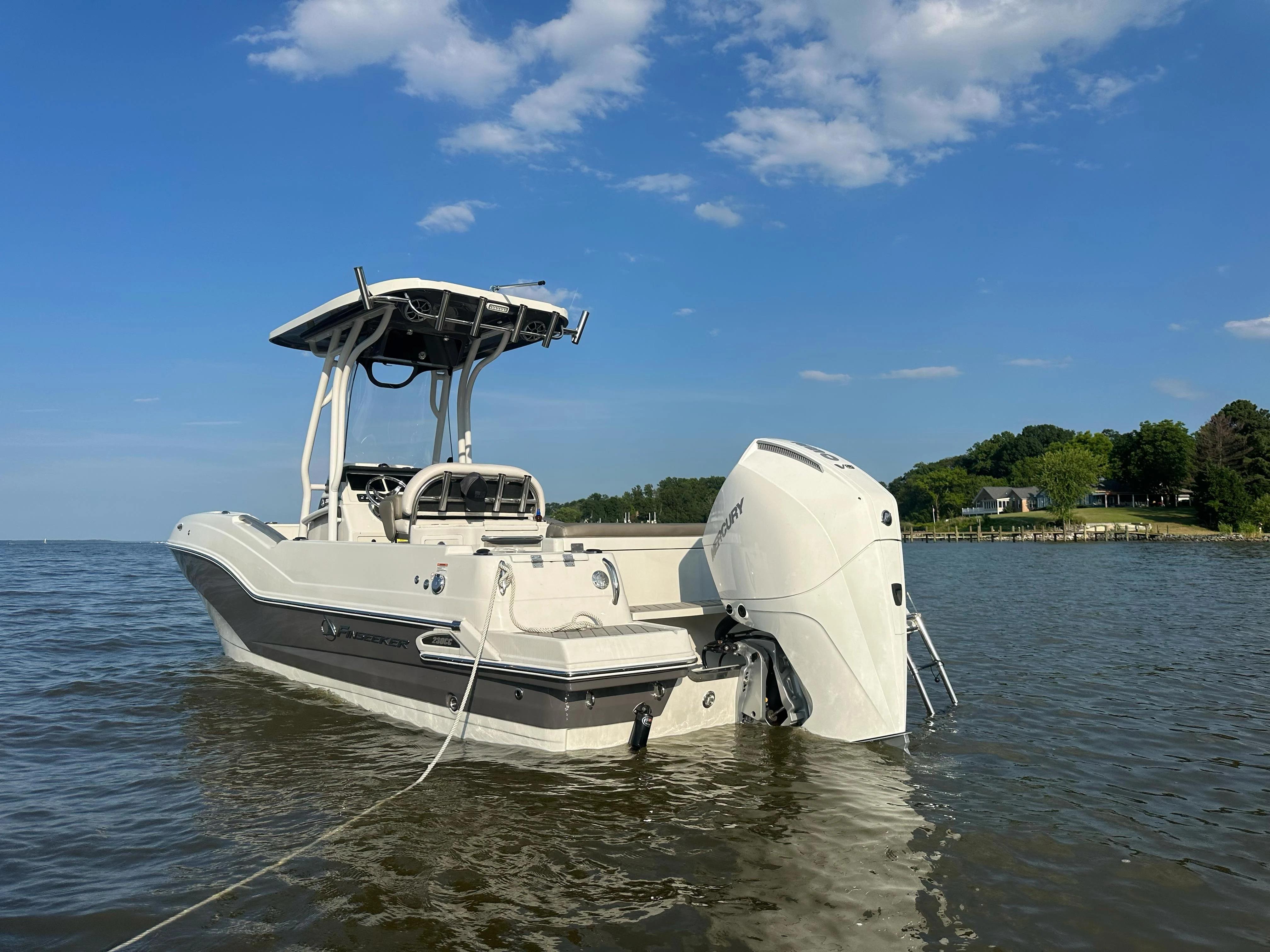 Finseeker 230 CC 2024 Finseeker 230 CC boat on calm water under a clear blue sky.