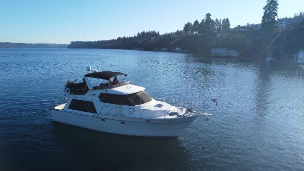Angel 48 1989 Angel 48 yacht cruising on a serene lake with forested shoreline.