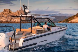 Axopar 37 Sun Top 2025 Axopar Sun Top cruising near rocky coastline at sunset, featuring sleek design and modern amenities.