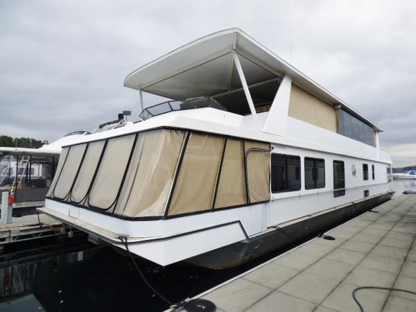 Stardust Cruisers 18x83 Houseboat docked at marina, Stardust Cruisers 18x83 model, year 2000, with covered upper deck.