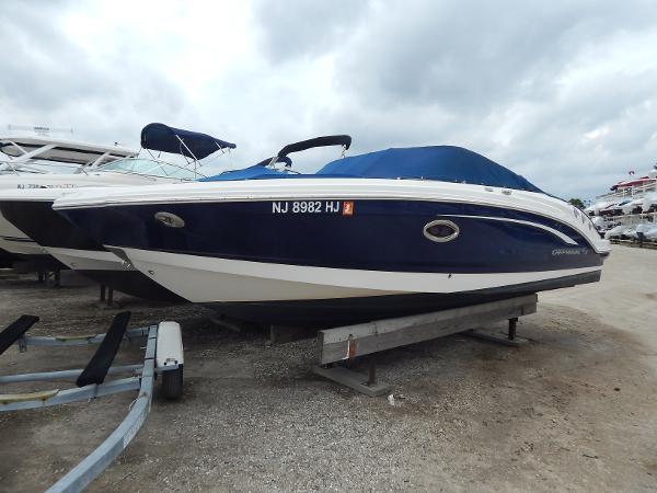 Chaparral 246 SSi 2016 Chaparral 246 SSi boat with blue cover on trailer, cloudy sky background.
