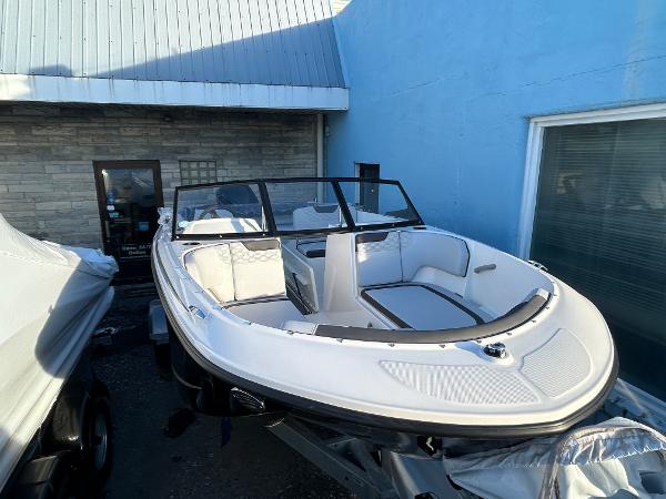 Bayliner Element M19 2024 Bayliner Element M19 boat displayed outdoors near a blue building.