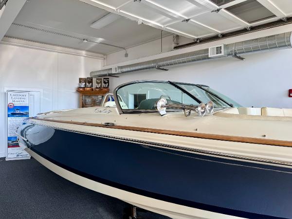 Chris-Craft Launch 27 2025 Chris-Craft Launch 27 boat in showroom, featuring sleek design and blue exterior.