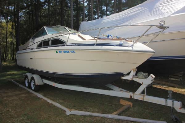 Sea Ray 245 SRV 1981 Sea Ray 245 SRV boat on trailer, parked outdoors near trees.