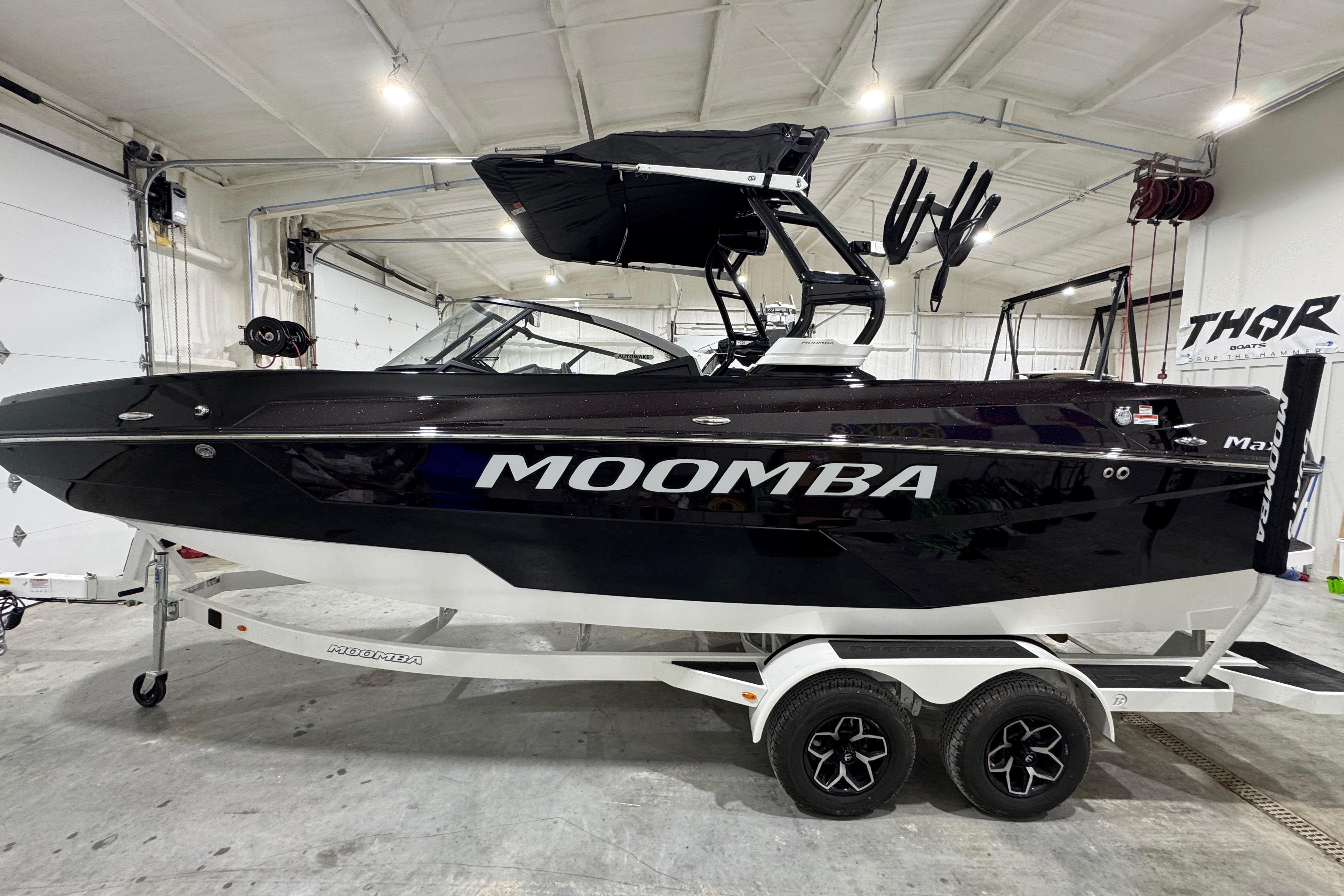 Moomba Max 2026 Moomba Max boat in a garage, black exterior, on a trailer.