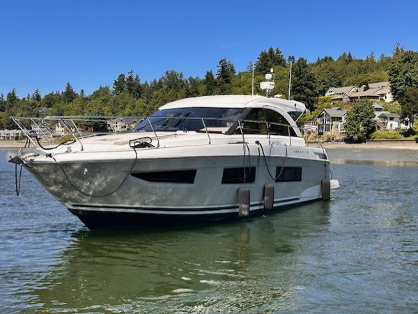 Jeanneau Leader 46 2017 Jeanneau Leader 46 yacht on calm water near a wooded shoreline.