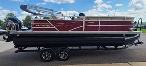 Ranger Reata 220C 2024 Ranger Reata 220C pontoon boat on trailer, parked outdoors under a blue sky.