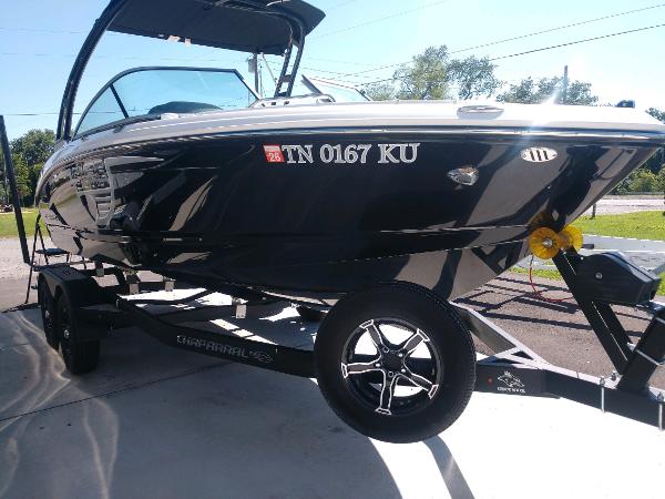 Chaparral 21 Surf 2023 Chaparral 21 Surf boat on trailer, black exterior, parked outdoors.
