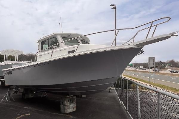 Parker 2320 Sl 2022 Parker 2320 SL boat on display, gray hull, parked on a lot near a highway.