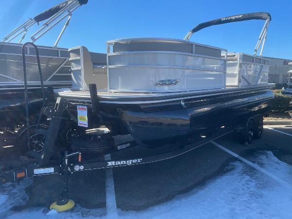 Ranger Reata 223C 2024 Ranger Reata 223C pontoon boat on trailer in parking lot.