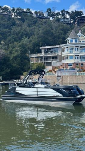 Montara Surfboss 2.0 2024 Montara Surfboss 2.0 boat on a lake with luxury homes in the background.