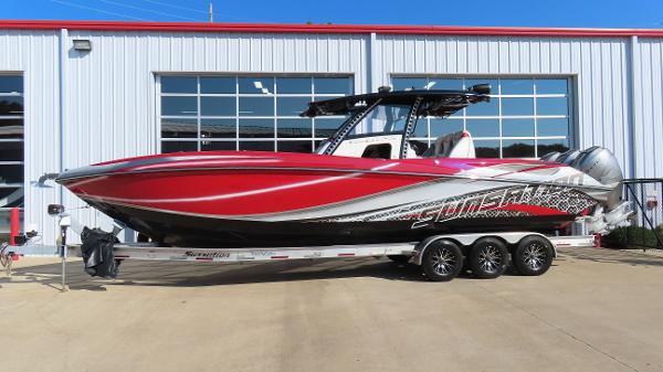 Sunsation 34 CCX 2014 Sunsation 34 CCX boat with red and silver design on a trailer.
