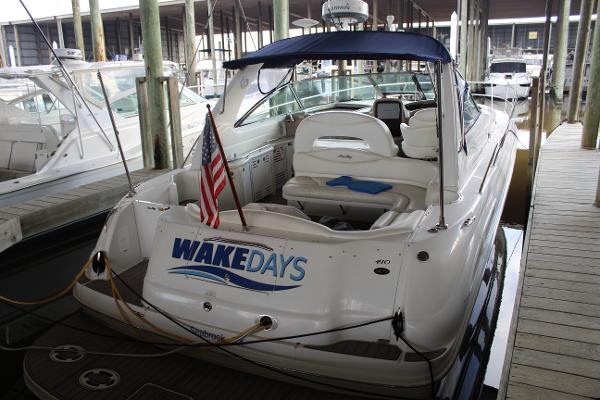 Sea Ray 410 Sundancer 2003 Sea Ray 410 Sundancer docked, rear view with WAKEDAYS signage and American flag.
