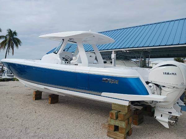 Intrepid 375 Nomad SE 2024 Intrepid 375 Nomad SE boat with blue hull, displayed on blocks, under a blue roof.