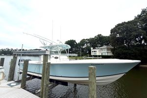 Regulator 34SS 2009 Regulator 34SS boat docked by waterfront home, surrounded by trees.