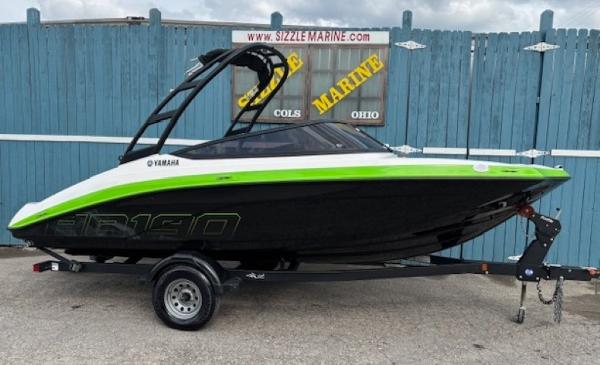 Yamaha Boats AR190 2022 Yamaha AR190 boat with green accents on a trailer, displayed outdoors.