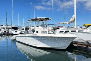 NauticStar 242L Offshore 2023 NauticStar 242L Offshore boat docked in a marina under clear blue skies.