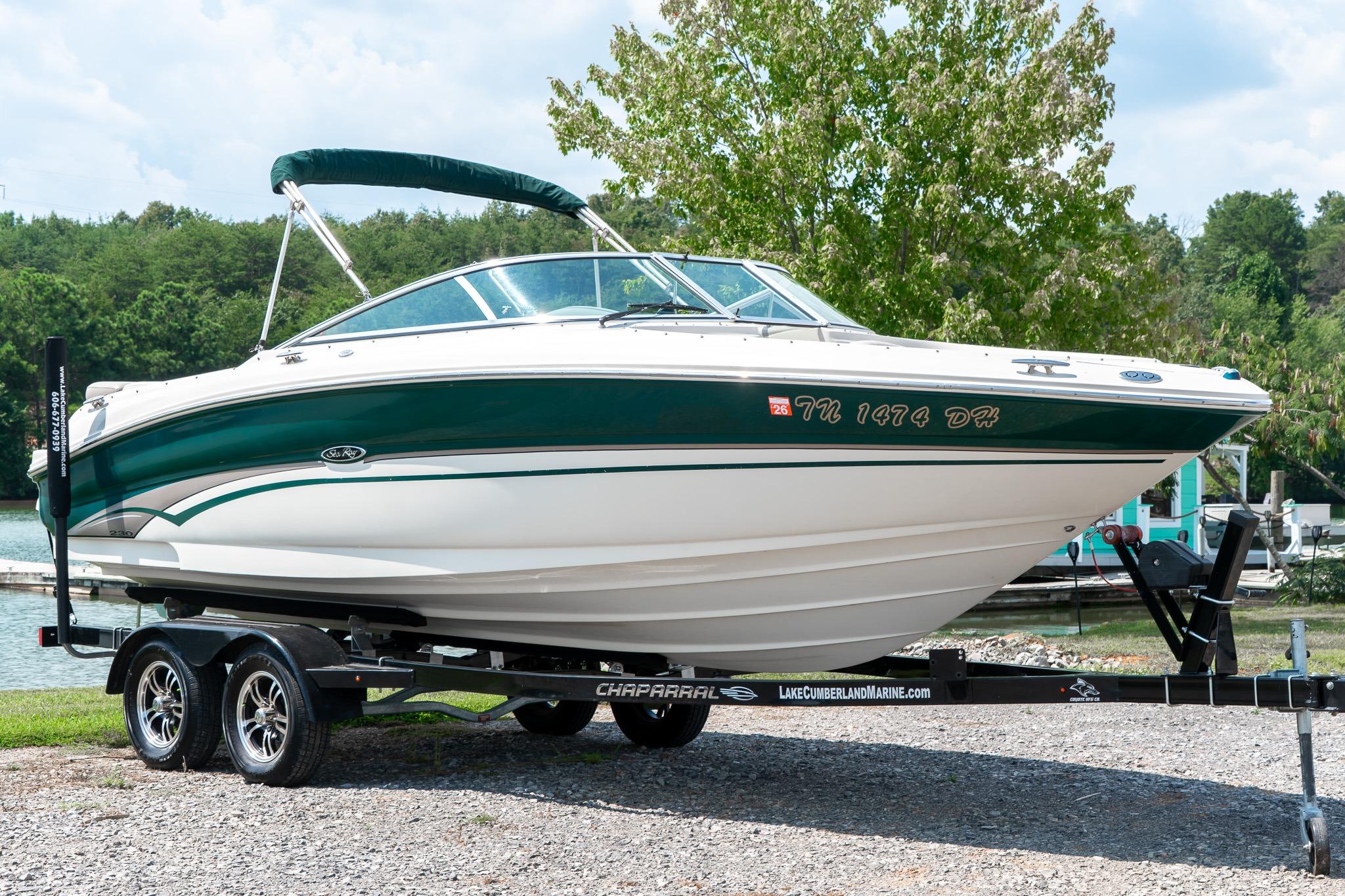 Sea Ray 230 Bow Rider 2002 Sea Ray 230 Bow Rider boat on trailer, parked near a lake with trees.