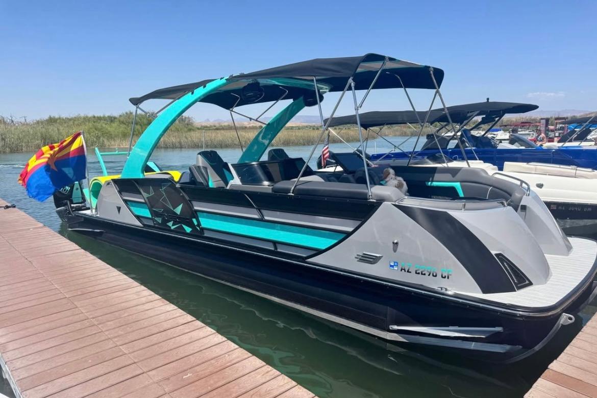 Trifecta Sport C9 DC 2024 Trifecta Sport C9 DC pontoon boat docked, featuring sleek design and vibrant colors.