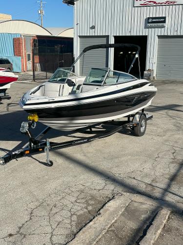 Crownline 210 SS 2025 Crownline 210 SS boat on trailer outside a warehouse.